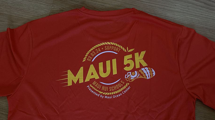 Red running t-shirt with the words Maui 5K and a shoe print.