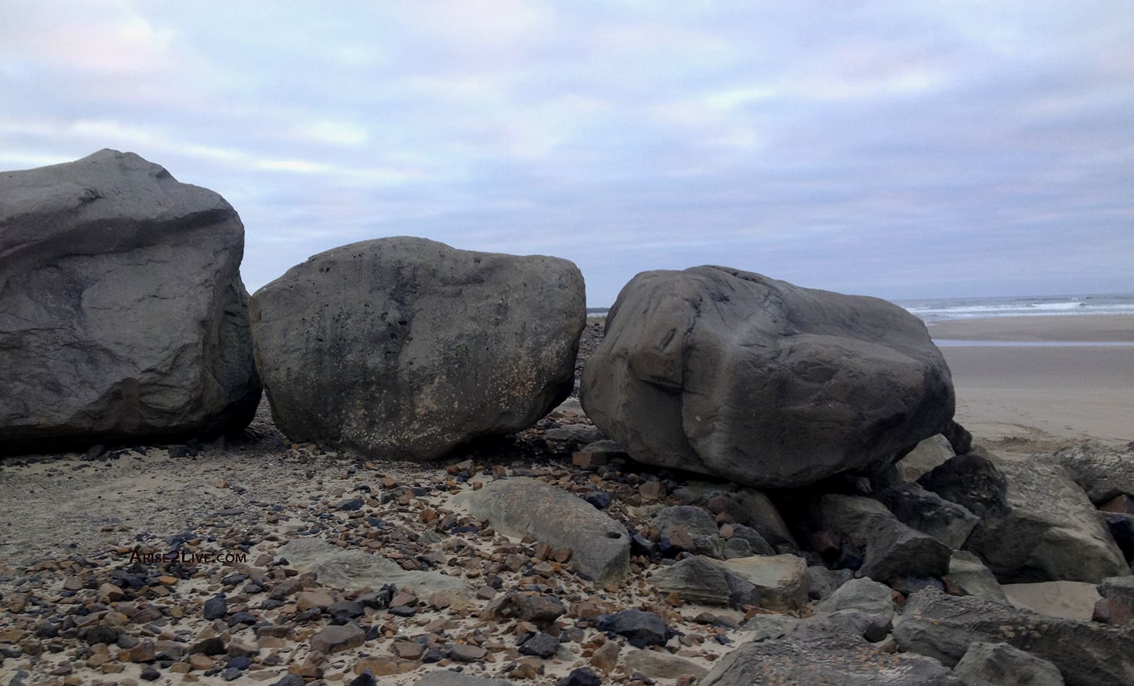 Three boulders under clouds blocking the path.